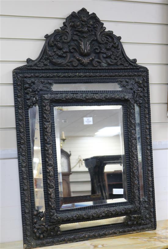 A brass embossed cushion mirror W.69cm